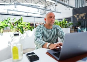 Man staying productive while traveling in airport lounge workspace