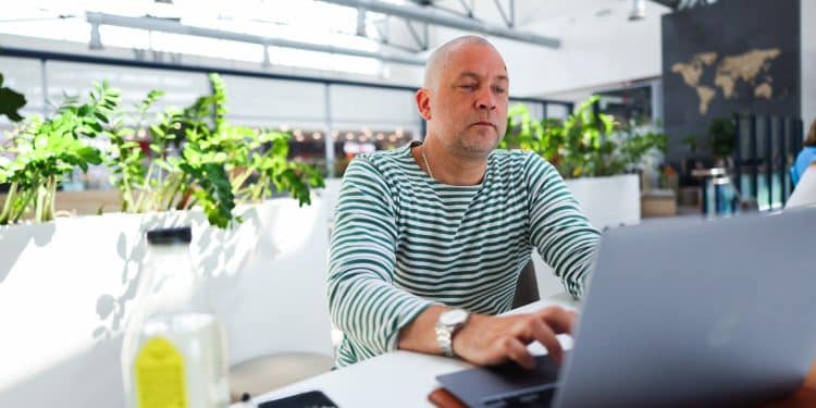 Man staying productive while traveling in airport lounge workspace