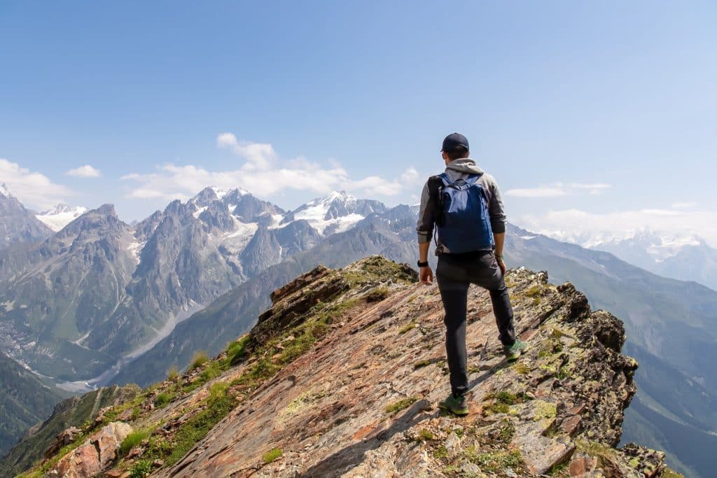 hiker on mountain ridge with Caucasus peaks