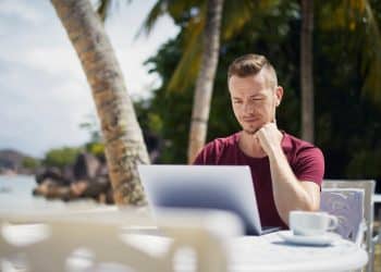 Digital nomad with laptop by the beach tax residency 183 day rule