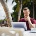 Digital nomad with laptop by the beach tax residency 183 day rule