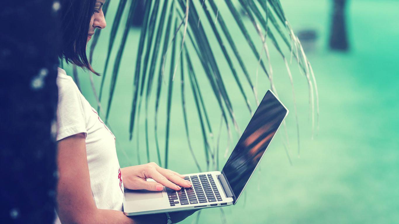 woman standing and using MacBook Air