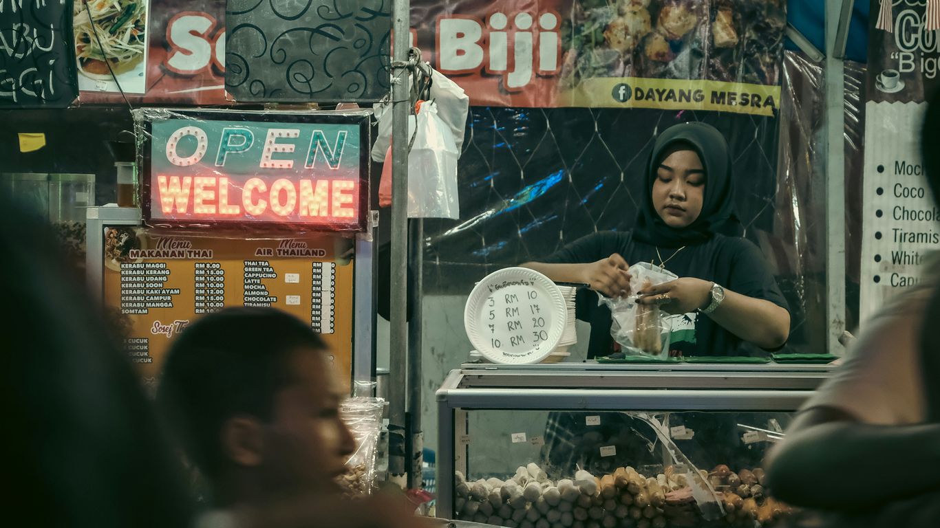 a woman standing in front of a food stand